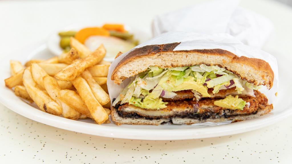 Torta De Milanesa · Breaded chicken breast, tomatoes, lettuce, onion, jalapeños, queso fresco, mayonnaise and black beans with a side of fries.