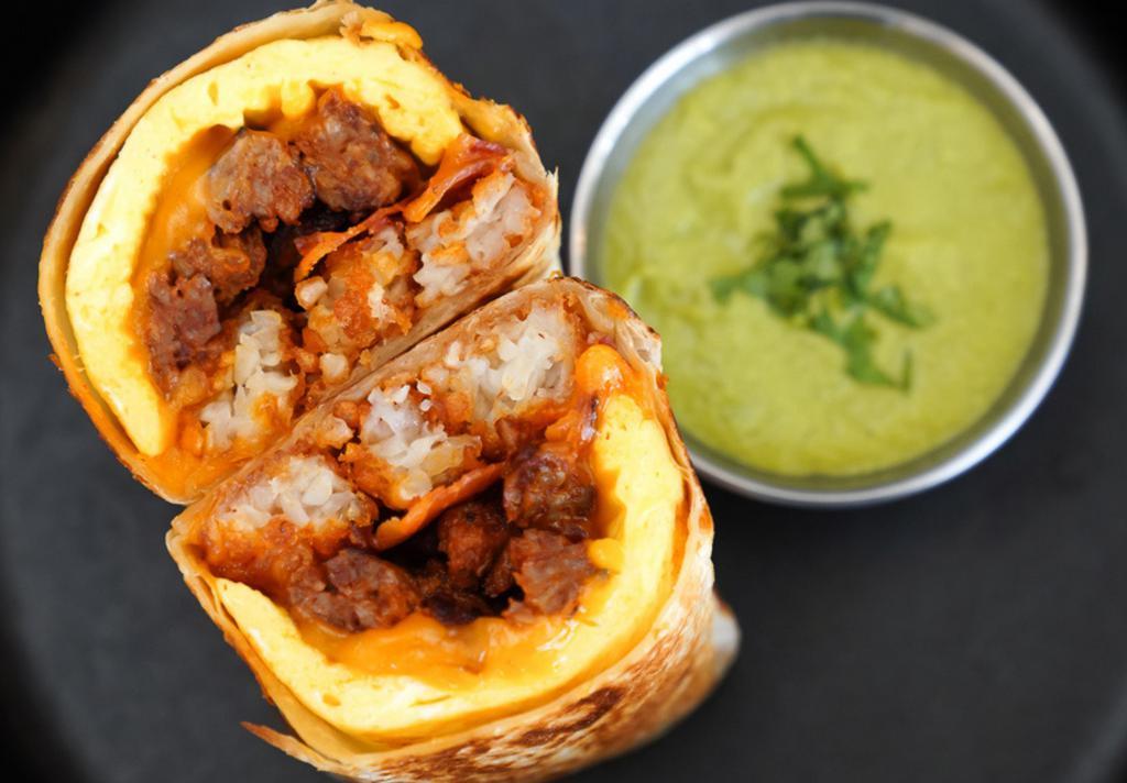 El Carnicero Breakfast Burrito · 3 fresh cracked cage-free scrambled eggs, melted Cheddar cheese, smokey bacon, spicy chorizo sausage, and crispy potato tots wrapped in a toasted 12” flour tortilla with a side of avocado salsa verde