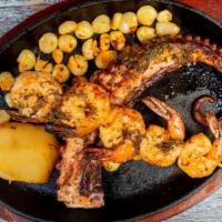 Pulpo A La Parrilla · Grilled octopus served with golden potato and Peruvian corn in delicious salsa anticuchera.