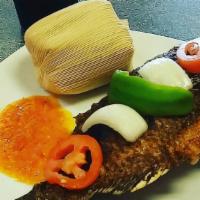 Kenkey With Fried Fish · Kenkey served with fried fish (tilapia or mackerel), bell peppers, onion,
and pepper sauce.