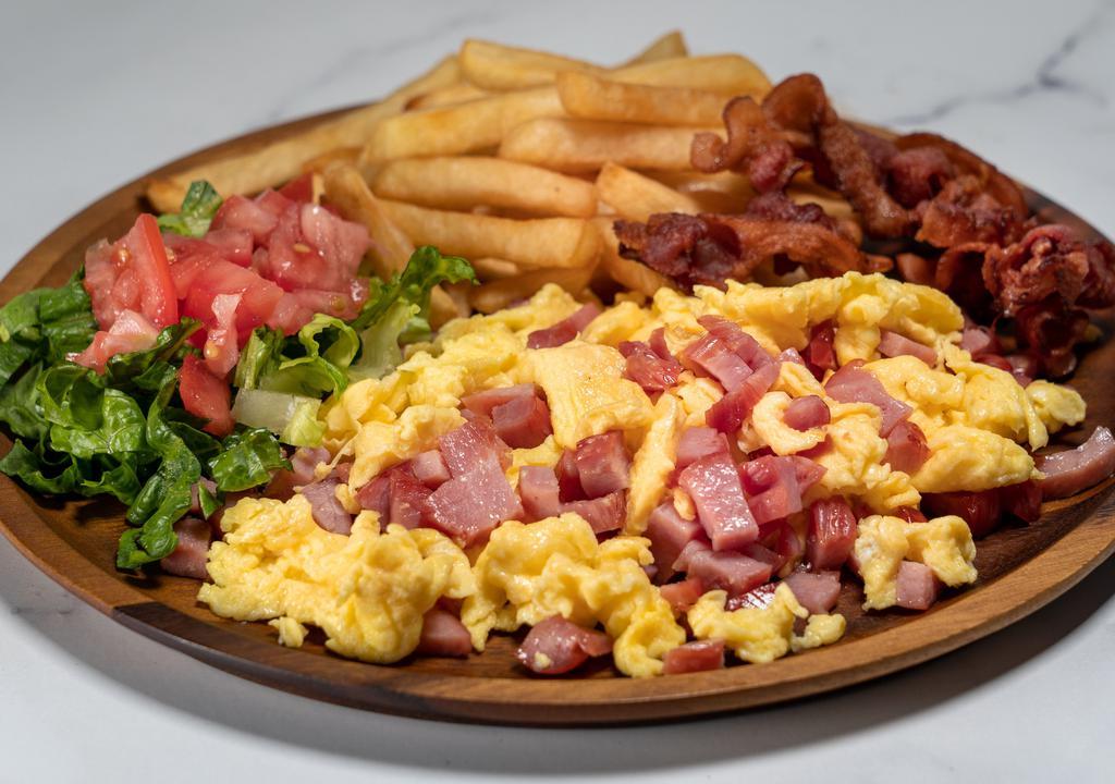 Huevos Revueltos · Scrambled eggs, ham or chopped sausage, bacon, French fries, small salad with tomatoes and lettuce, butter toast and café con leche included.