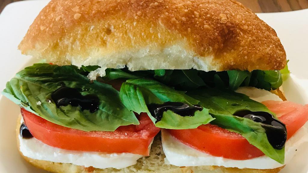 Caprese Panini · Slices of the Finest Fresh Mozzarella, fresh sliced tomatoes, crisp arugula and fresh cut basil. Served in between oven warm Italian Artisan Bread and brushed with our Italian herb oil.