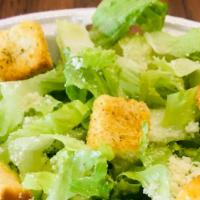 Side Ceasar Salad · Crisp Romaine lettuce, grated Parmesan cheese topped with buttery croutons and a side of Cae...