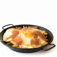 Huevos Estrellados · A very Typical Spanish dish with french fries topped with three fried eggs and serrano ham o...