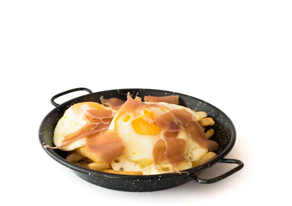 Huevos Estrellados · A very Typical Spanish dish with french fries topped with three fried eggs and serrano ham or chistorra