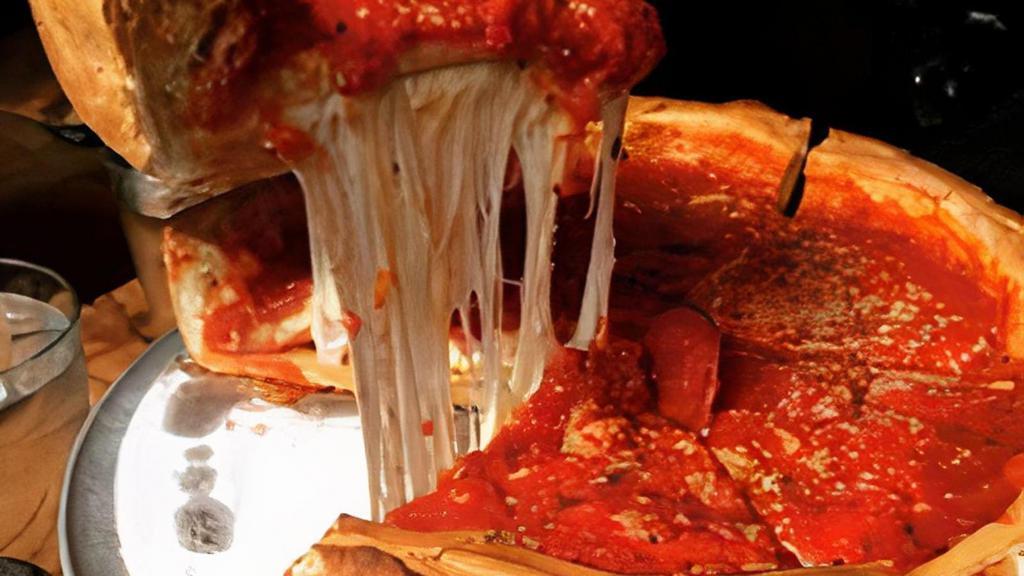 Meat Lovers Chicago Stuffed Pizza · It is a deeper layer of dough-dish pizza,We stuff with mozzarella cheese,Pepperoni, Italian sausage, apple wood smoked bacon, diced ham, grilled chicken, beef, and when it is baked we topped with marinara sauce and sprinkles of parmesan cheese.