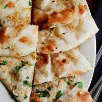 Garlic Naan · Naan bread baked in tondoori clay oven topped with fresh minced garlic and cilantro,