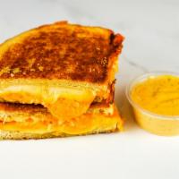 Three Cheese Grilled Cheese · Cheddar, Swiss, and Parmesan cheeses melted between buttery, toasted sourdough bread. Served...