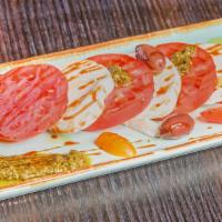 Ensalada Capri · Tomato, fresh  mozzarella, basil, pesto and balsamic vinegar reduction