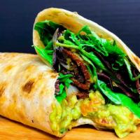 Guac Bacon Wrap · Homemade guacamole, hickory smoked tempeh bacon, tomatoes, grilled onions, mixed greens on a...