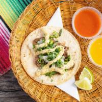 Steak  Taco · Marinated steak topped with creamy chimichurri sauce, onions and cilantro