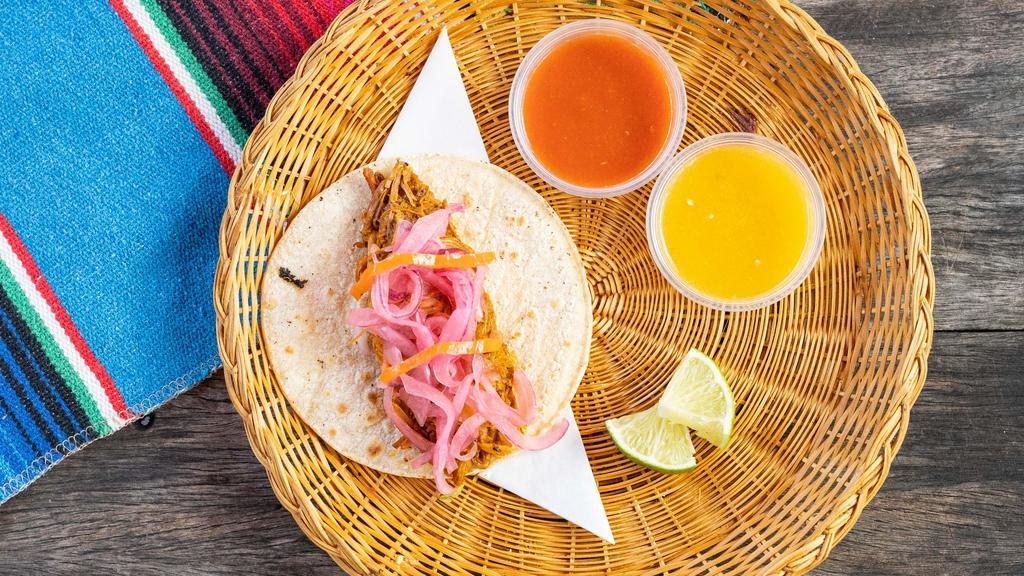 Cochinita Pibil Taco · Spicy. Pulled pork cooked in a red achiote salsa, topped with pickled red onion and habanero Chile.