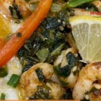 Cajun Shrimp & Grits Bowl · Stoned ground grits topped with grilled shrimp tossed in a cajun butter garlic with green pe...
