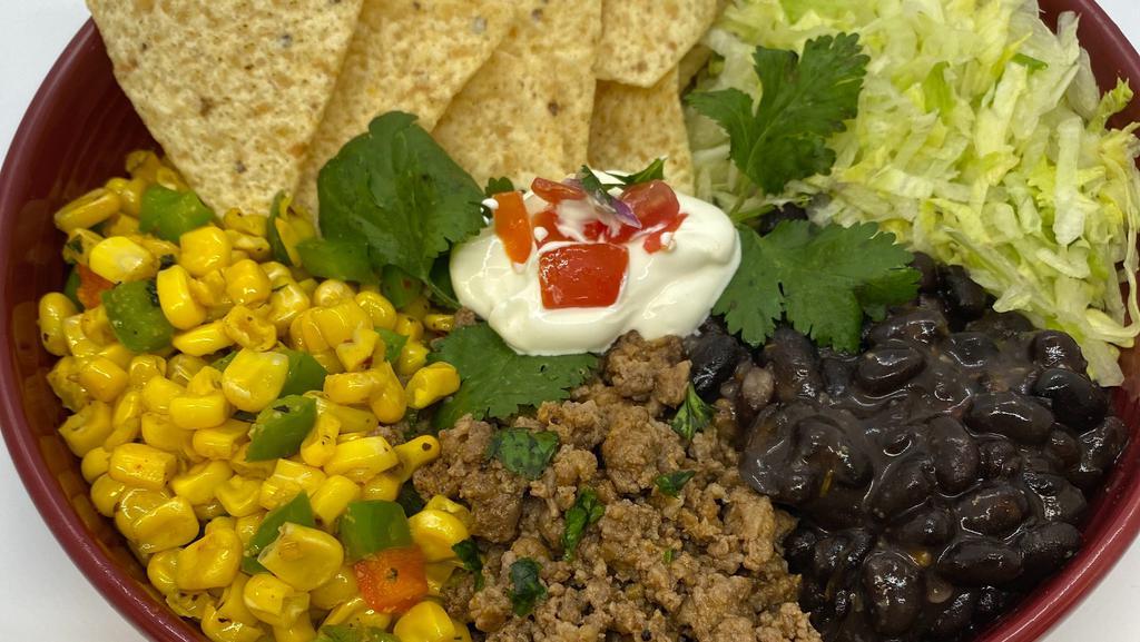 Mexican Taco Bowl · Roasted corn, black beans, seasoned ground beef, shredded lettuce, shredded cheddar cheese, a side of sour cream, salsa and tortilla chips