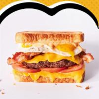 Rise N Shine Melt · Hamburger patty, American cheese, 2 fried eggs, bacon, tomatoes and Awesome Sauce on white b...