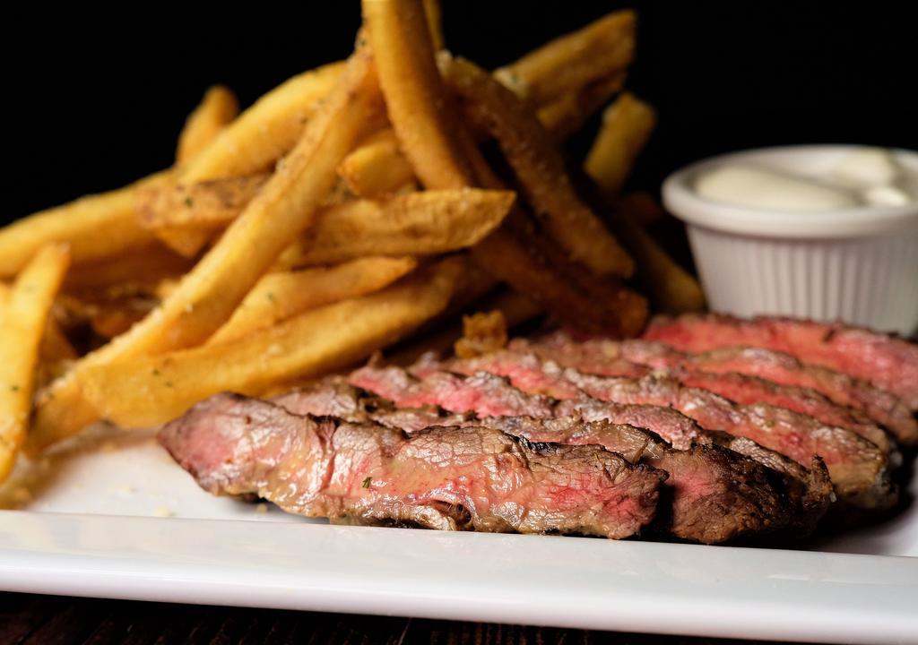 Steak Frites · 10 oz marinated flat iron steak, sliced with herb butter and served with parmesan truffle fries.