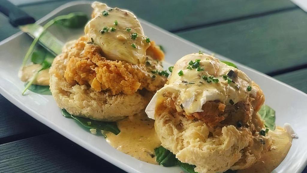Chicken St. Charles · Fried chicken over a housemade buttermilk biscuit with two poached eggs, finished with a pork tasso cream sauce
