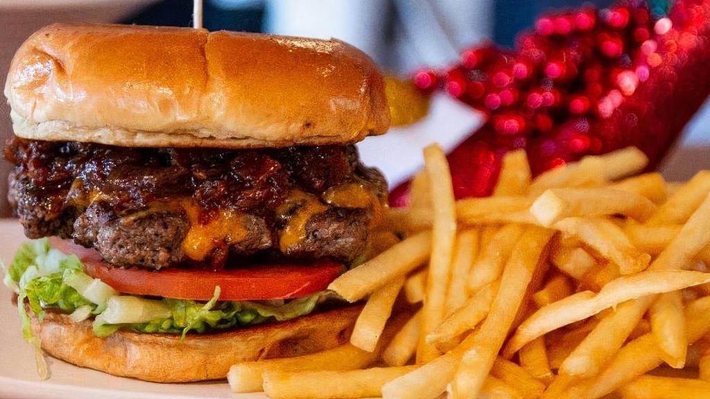 Burger · A classic burger topped with cheddar cheese, red onions, lettuce, tomato, pickles, bacon onion jam & mayonnaise on a brioche bun, served with choice of side