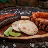 Picadita Mi Tierra · Fried pork rind, Colombian sausage and Colombian blood sausage with arepa (corn cake).