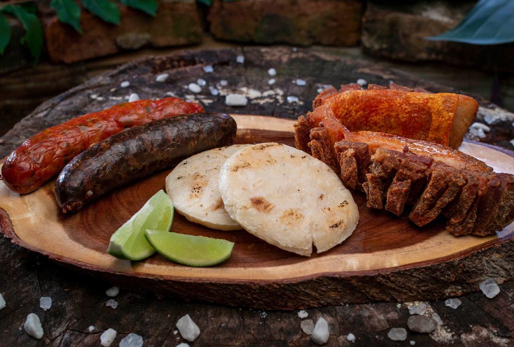 Picadita Mi Tierra · Fried pork rind, Colombian sausage and Colombian blood sausage with arepa (corn cake).