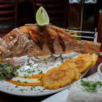 Pargo Frito · Whole deep fried red snapper, served with white rice, fried green plantains and salad.