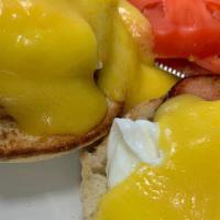 Eggs Benedict · English muffin topped with Canadian bacon, poached eggs, and hollandaise sauce. Served with ...