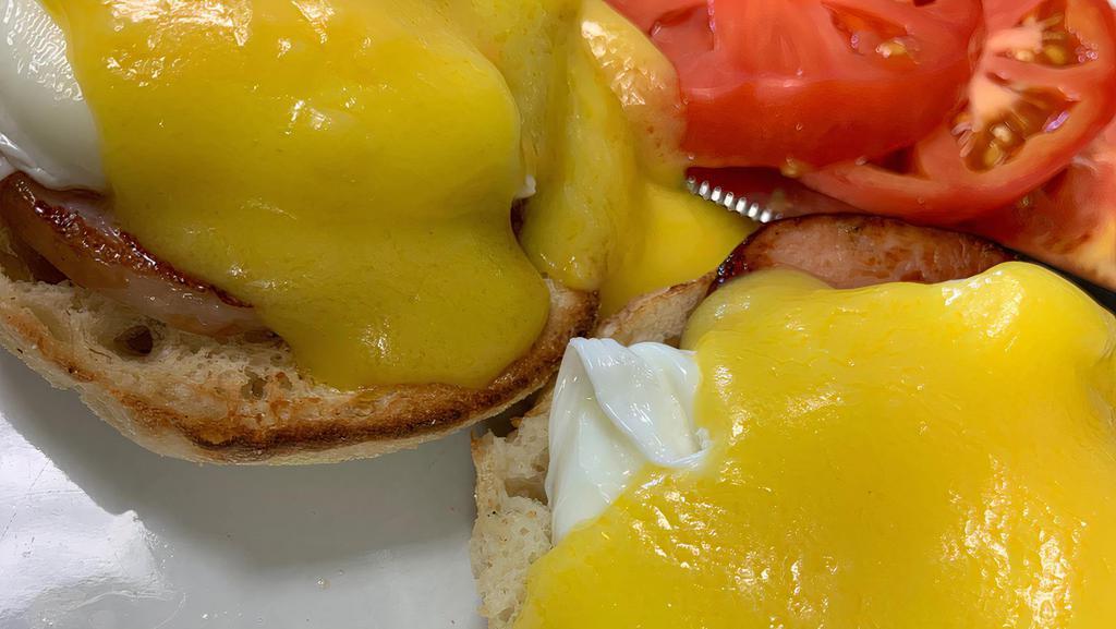 Eggs Benedict · English muffin topped with Canadian bacon, poached eggs, and hollandaise sauce. Served with one side.