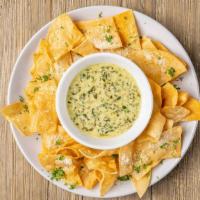 Spinach Dip · Creamy spinach dip topped with parmesan cheese served with freshly made corn tortilla chips.