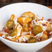 Cheesy Sidewinders · Crispy beer-battered potatoes with warm beer cheese, topped with sour cream, jalapeños and b...