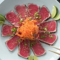 Tuna Tataki · Thin slices of seared tuna w/ Japanese spices, scallions, sesame seeds, and ponzu sauce.
