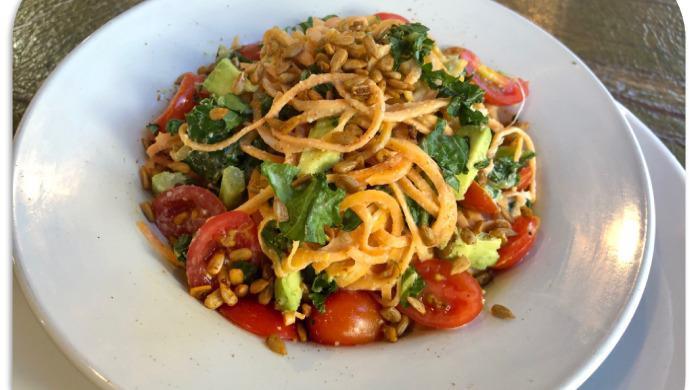 Sweet Potato Noodles · Vegan. Spiralized Sweet Potato sauteed with Kale, Grape Tomato, and Avocado with Garlic and Lime Sauce topped with Toasted Sunflower Seeds
