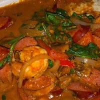 Shrimp & Grits · Grilled shrimps, beef andouille sausage, sautéed red peppers, and spinach, served in a red w...