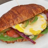 Fried Egg Sandwich · 2 fried eggs, bacon, cheese, spinach, tomatoes, avocado and onion on a big homemade croissan...