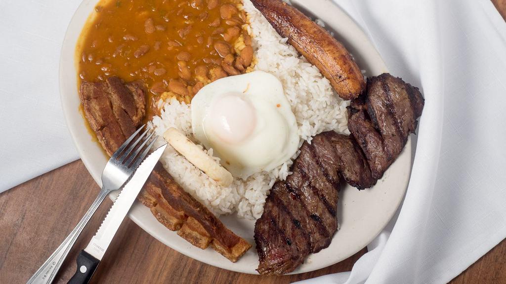 Bandeja Paisa · Typical colombian platter with rice, beans, pork skin, fried eggs, plantains, com cake and a choice of steak or ground beef.