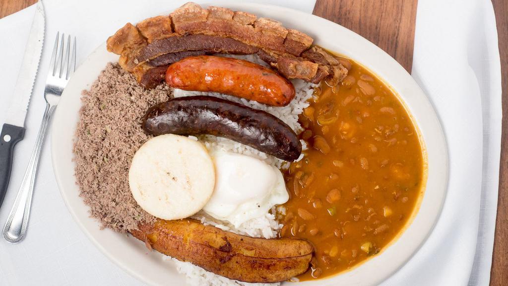Bandeja Super Mi Pueblo · Typical colombian platter with rice, beans, pork skin, fried eggs, plantains, corn cake and a choice of steak or ground beef plus Spanish sausage and blood sausage.