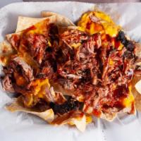 Bbq Nachos · A bed of tortilla chips topped with our low, slow, hickory-smoked pulled pork, melted cheese...