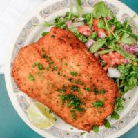 Chicken Milanese · Breaded chicken breast served with arugula, tomato and onion salad.