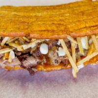 Patacon Pernil · Green plantain, shredded pork, Guayanes cheese, homemade sauce and potato sticks. Fried gree...