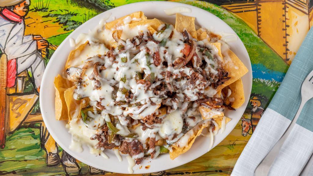Fajita Nachos · Chicken or steak sizzling fajitas served on a bed of crispy ships with grilled veggies and cheese sauce.