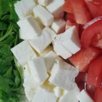 Tricolore · Baby arugula, fresh mozzarella, and fresh tomatoes served with honey balsamic dressing