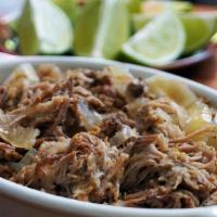 Lechón Asado · Pulled oven roasted pork grilled with onions and garlic mojo sauce.