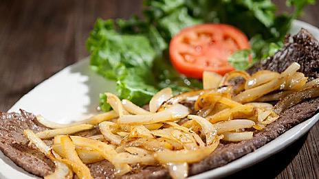 Bistec De Palomilla · Thin cutlet of choice top round steak fully seasoned and grilled to perfection, finished with fresh grilled onions.
