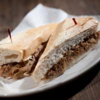 Pan Con Lechon · Tender pieces of roast pork, pulled and grilled with fresh sautéed onions and a touch of hav...