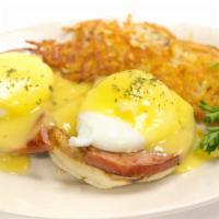 Eggs Benedict · Two poached eggs, ham and hollandaise sauce on an English muffin with home fries, hash brown...