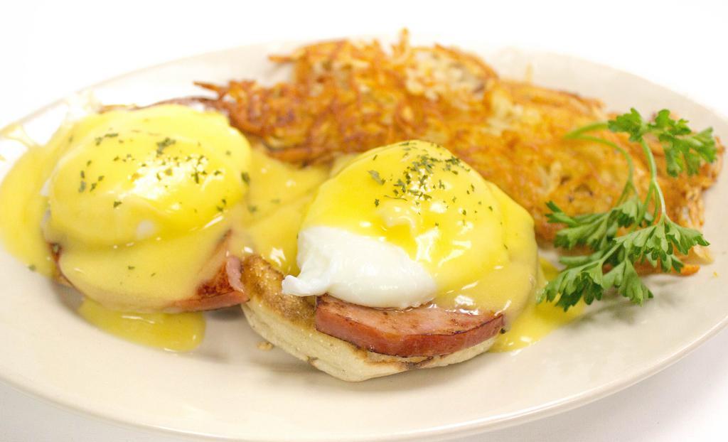 Eggs Benedict · Two poached eggs, ham and hollandaise sauce on an English muffin with home fries, hash browns or grits.