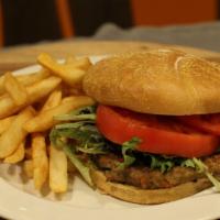 Veggie Burger · Vegan burger patty grilled and served on a bun with lettuce and tomato.
