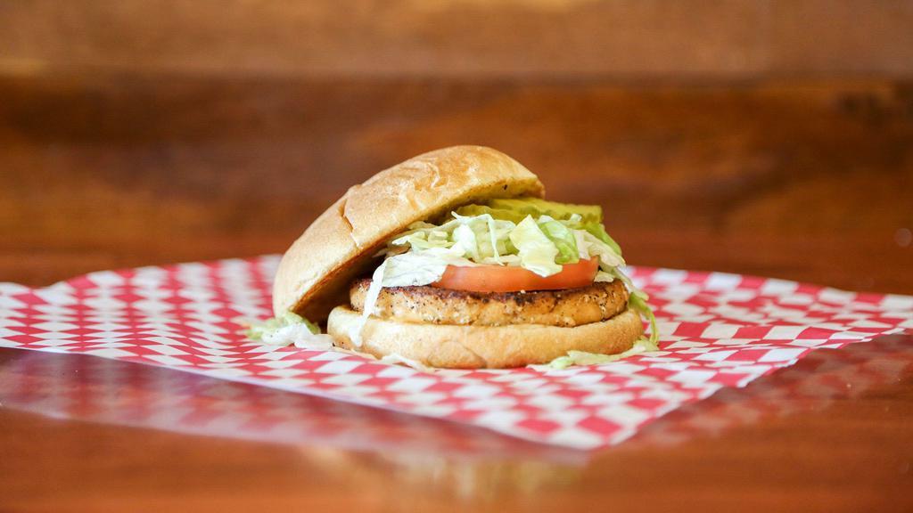 Salmon Burger Sandwich · Served grilled with surf sauce, crispy lettuce, tomato, pickles, and fries.