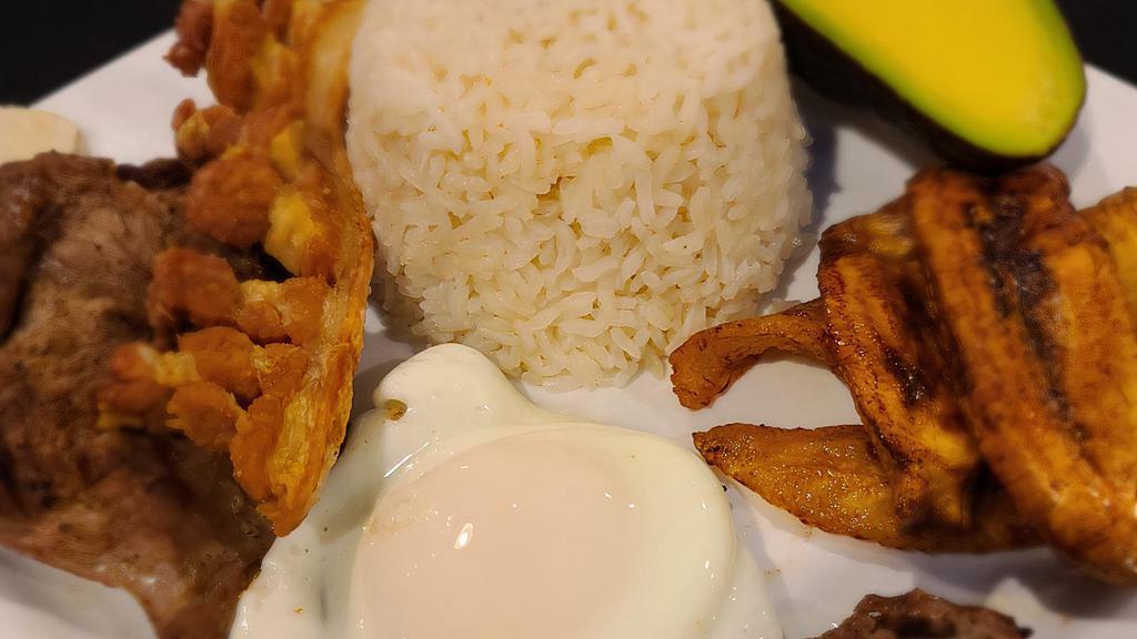 Bandeja Paisa · Combination platter. Grilled steak or grounded meat, sausage, fried pork skin, fried egg, sweet plantains, white rice, red bean, and corn cake. Add avocado for an additional charge.