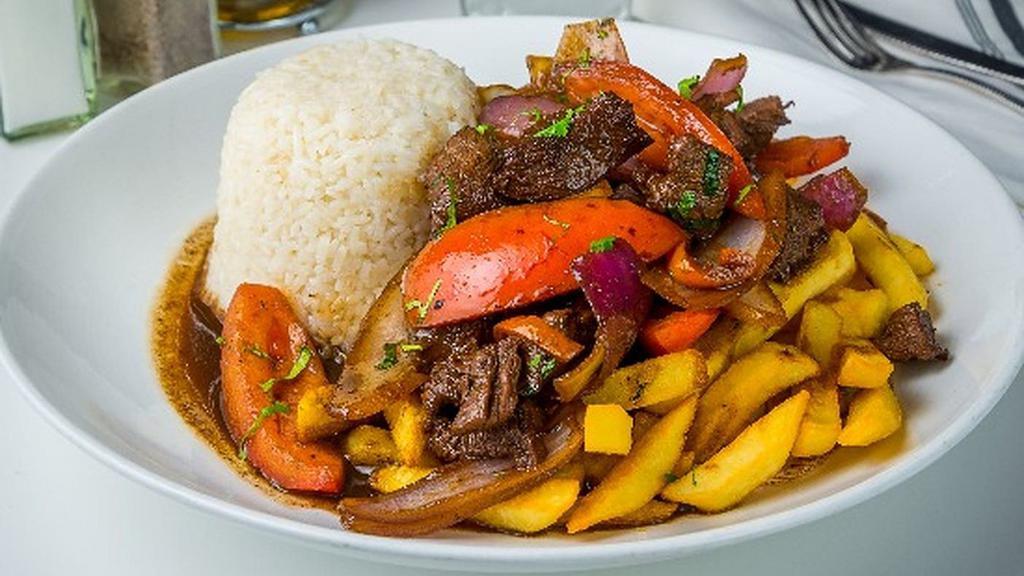 Lomo Saltado · Soft pieces of tenderloin, onions, tomatoes, yellow pepper and aromatic cilantro sauteed in our fiery wok. Served with crunchy french fries and delicious white rice.