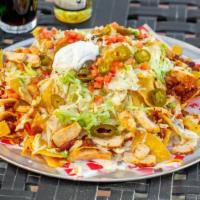Trash Panda Nachos · Tower of tortilla chips, chicken, queso, sour cream, pickled jalapenos, shredded cheddar, le...